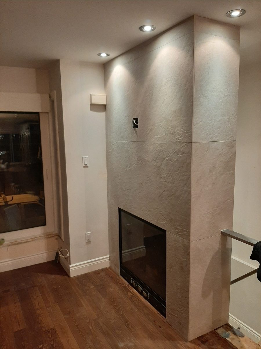 Fireplace wrapped in large-format limestone-look tile